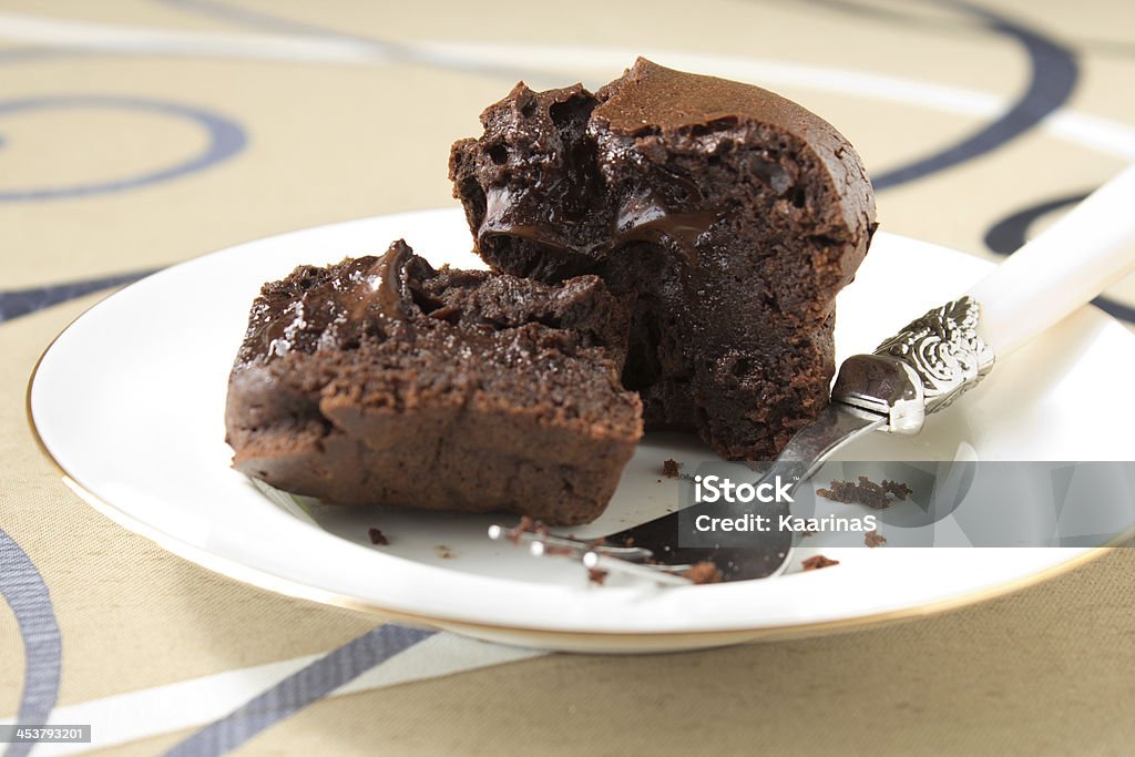 Chocolate muffins Small french chocolate cake with fondant core cut on white plate Brownie Stock Photo