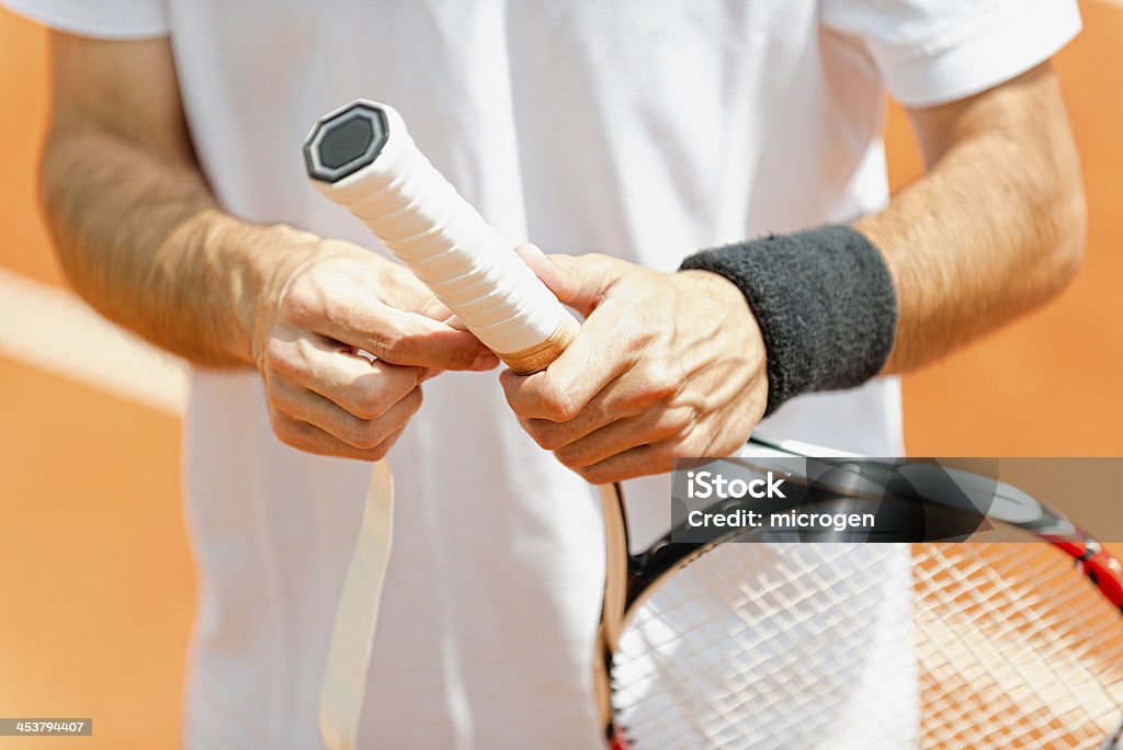 Putting new grip tape on tennis racket Tennis professional putting new grip tape on tennis racket Tennis Stock Photo