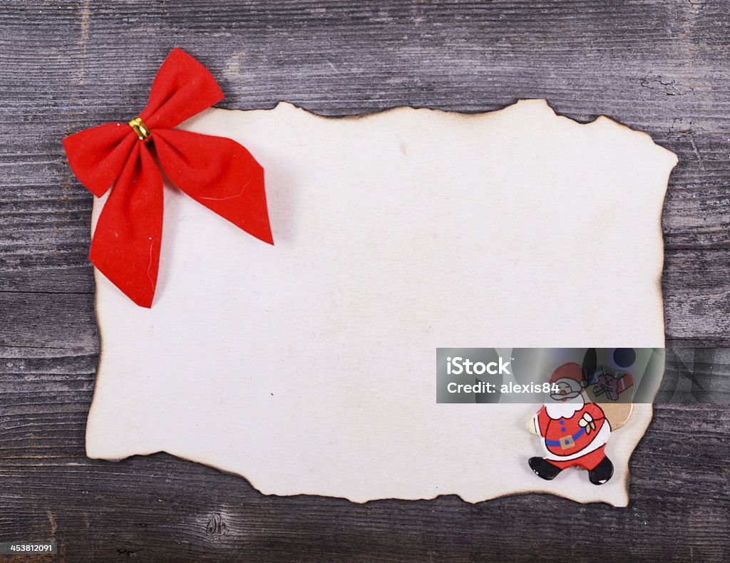 Papel en blanco againts fondo de madera con lazo rojo - Foto de stock de Agarrar libre de derechos
