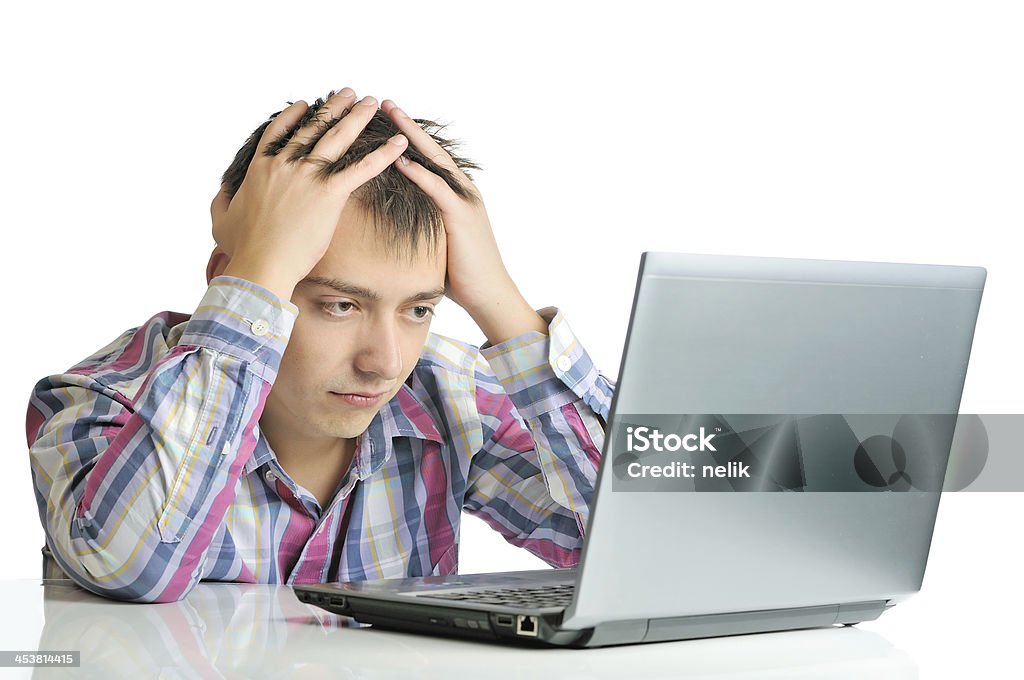 Stressed out businessman Stressed out businessman isolated on white background. A man holding his head in frustration while working on his computer. Headache Stock Photo