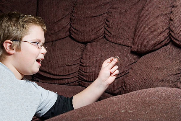 Young white child finding money in a sofa stock photo