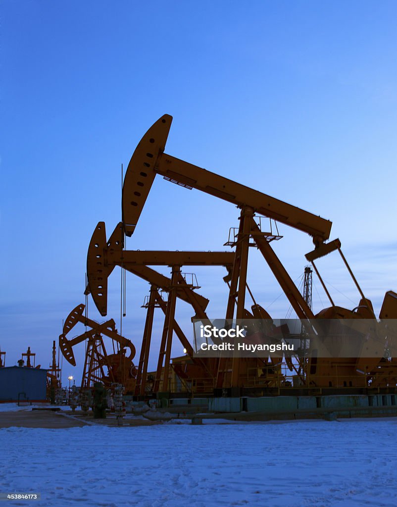 Oil pumps Oil pumping Unit at sunset time Crude Oil Stock Photo
