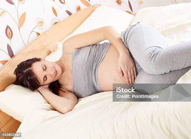 Pregnant Woman Lying In Bed Stock Photo - Download Image Now - 20-29 Years, Abdomen, Adult