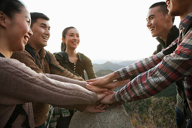 istock Group of young people holding hands together on the stone 453853075