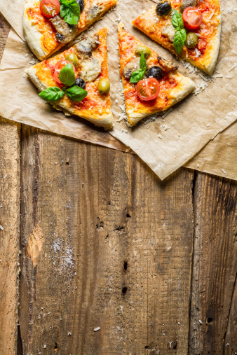 Fresh pizza on paper and old wooden table as background 8.