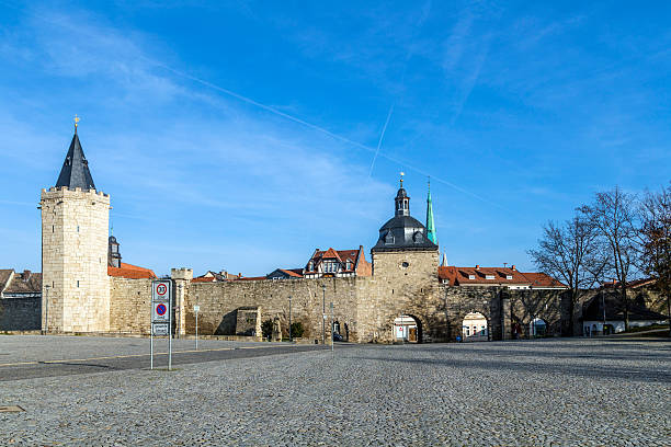 muehlhausen, donna che porta alla storica città di parete con raven tower - mühlhausen foto e immagini stock