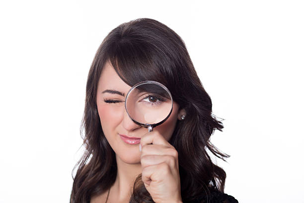 istock Beautiful woman looking through a magnifying glass 453868759