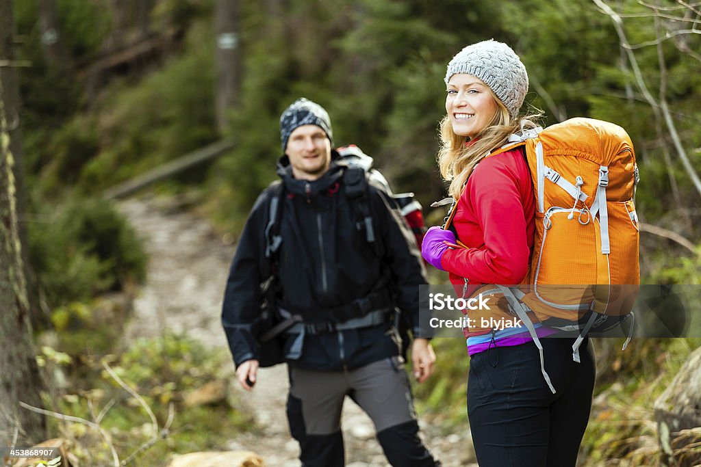 Couple happy hikers walking in forest Man and woman hikers trekking in mountains. Young couple walking with backpacks in forest, Tatra Mountains in Poland. Trekking hiking outdoors in beautiful nature Achievement Stock Photo