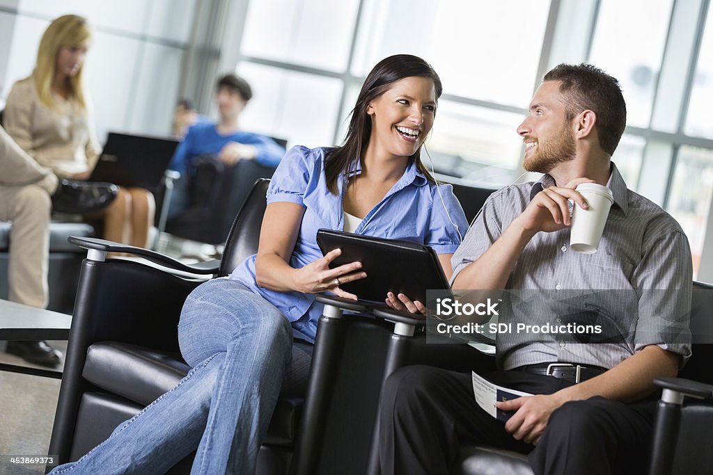 Junge Erwachsene Paar wartet im geschäftigen Flughafen-Terminals für Abflug - Lizenzfrei Abflugbereich Stock-Foto