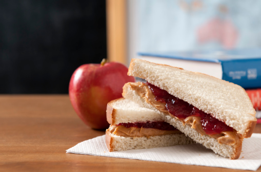 Peanut butter and jelly sandwich in  a classroom with a apple.  Please see my portfolio for other education and food related images.