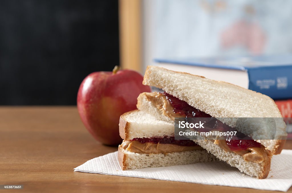 Peanut Butter and Jelly Sandwich Peanut butter and jelly sandwich in  a classroom with a apple.  Please see my portfolio for other education and food related images. Peanut Butter And Jelly Sandwich Stock Photo