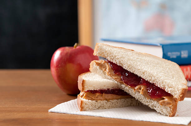 Peanut Butter and Jelly Sandwich Peanut butter and jelly sandwich in  a classroom with a apple.  Please see my portfolio for other education and food related images. peanut butter and jelly sandwich stock pictures, royalty-free photos & images