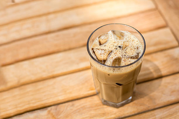 istock Cold ice coffee with cubes on wooden table 453878669
