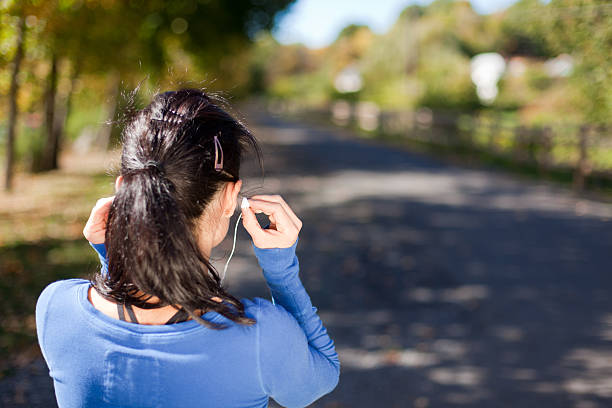 rear view woman with earbuds - horizontal 2 stock photo