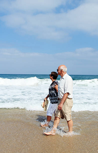 istock Happy senior couple walking together on a beach 453885705
