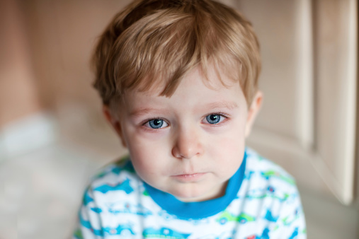 Crying toddler boy with blue eyes and blond hairs