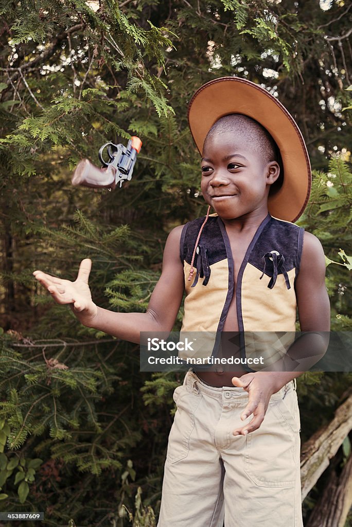 Little black Cow-boy garçons jouant avec un pistolet en plastique. - Photo de Pistolet en plastique libre de droits