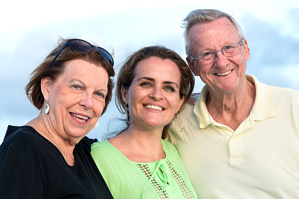 Senior couple posing with their daughter Smiling Senior couple posing with their daughter grandmother real people front view head and shoulders stock pictures, royalty-free photos & images