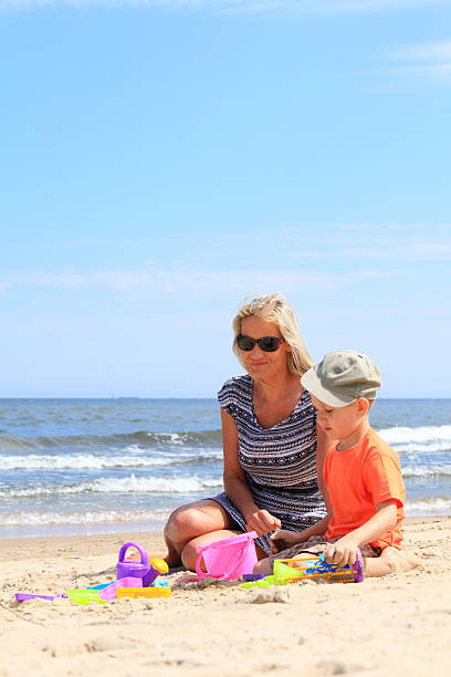istock Son and mother playing toys on beach 453897231