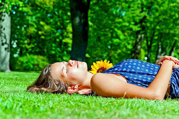 istock Young girl lying on green grass 453899867