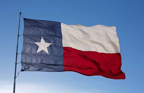 Flag of Texas on the wind against blue sky stock photo