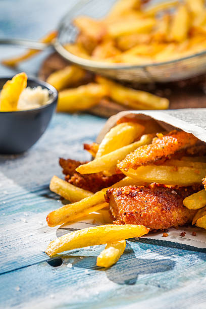 istock Close-up of fish and chips wrapped in newspaper 453902929