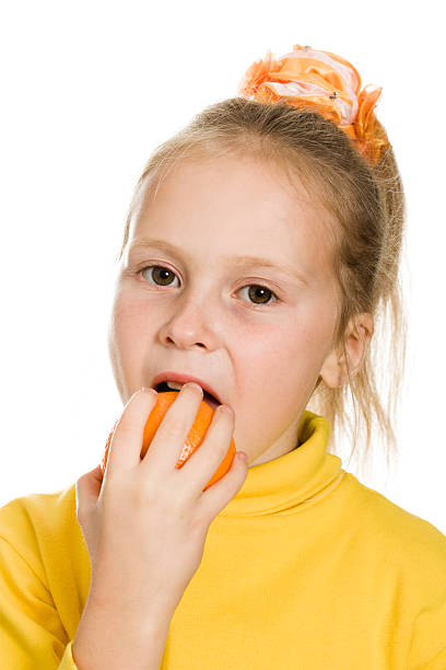 istock cute girl biting an orange 453905087