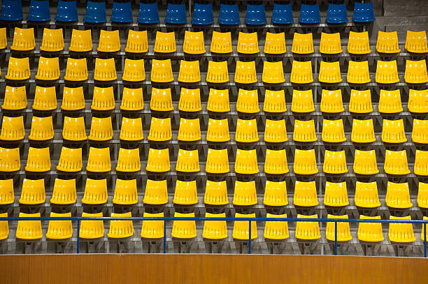 istock Plenty of yellow and blue plastic seats at stadium . 453913747