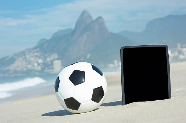 футбол футбольный мяч планшетный компьютер ipanema пляж рио-де-жанейро - computer monitor nobody two brothers mountain travel destinations стоковые фото и изображения