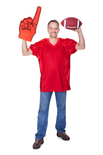 Happy Man Wearing Foam Finger And Holding Rugby Ball On White Background