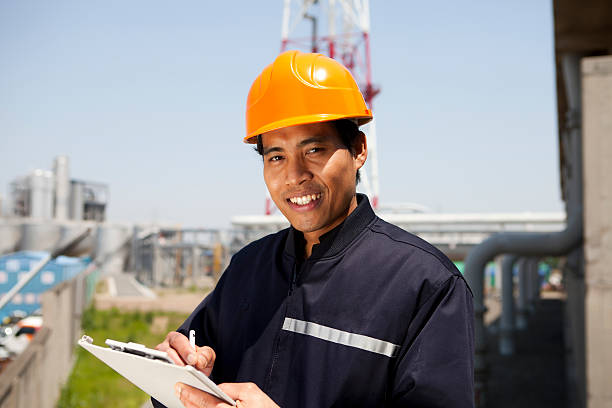 istock A man wearing a yellow helmet writing on a clipboard 453919865