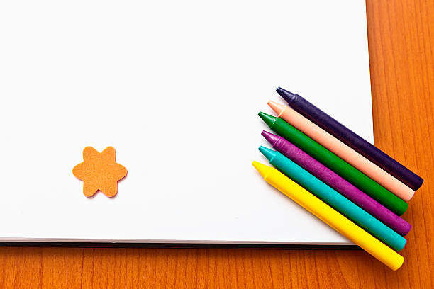 istock Diagonal line of wax crayons plus star on sketchbook 453921387