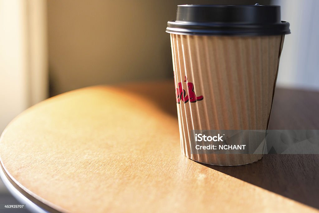 Disposable Coffee Cup Disposable Coffee Cup in the morning sun, sitting on a bar leaner. Backgrounds Stock Photo