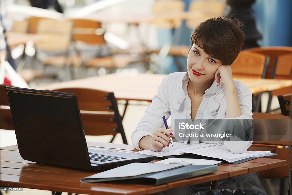 Young businesswoman with laptop at a sidewalk cafe Public Park Stock Photo