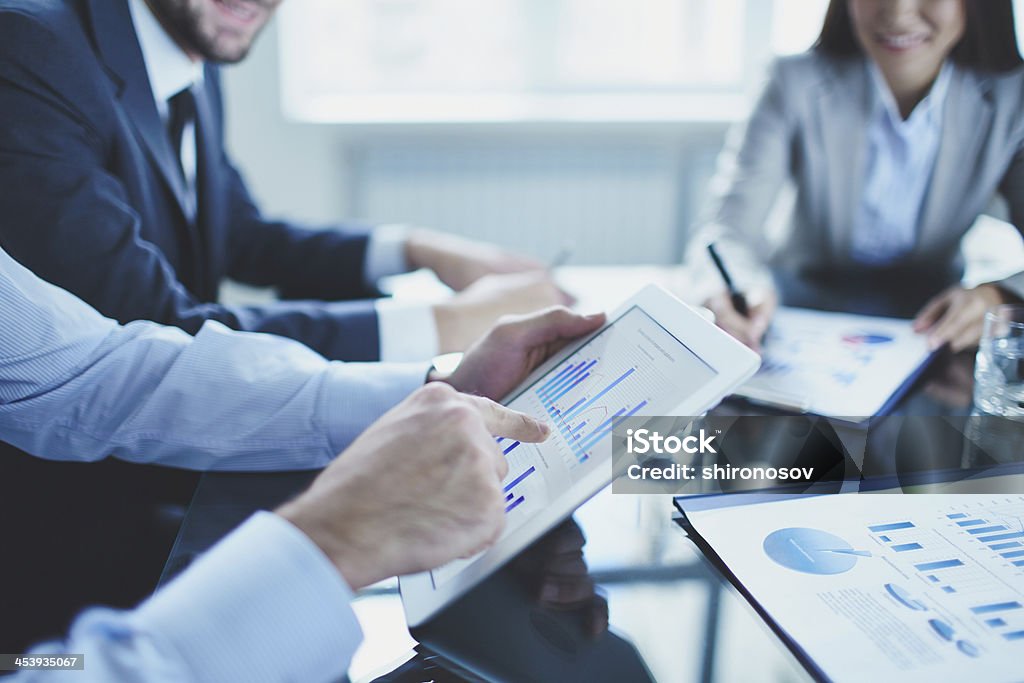 Explaining data Image of businessperson pointing at document in touchpad at meeting Adult Stock Photo