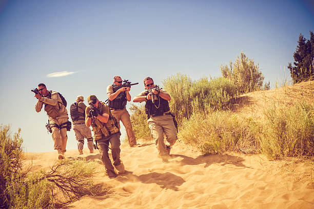 istock Special Ops Officers With Rifles On Sand Dunes 453941883