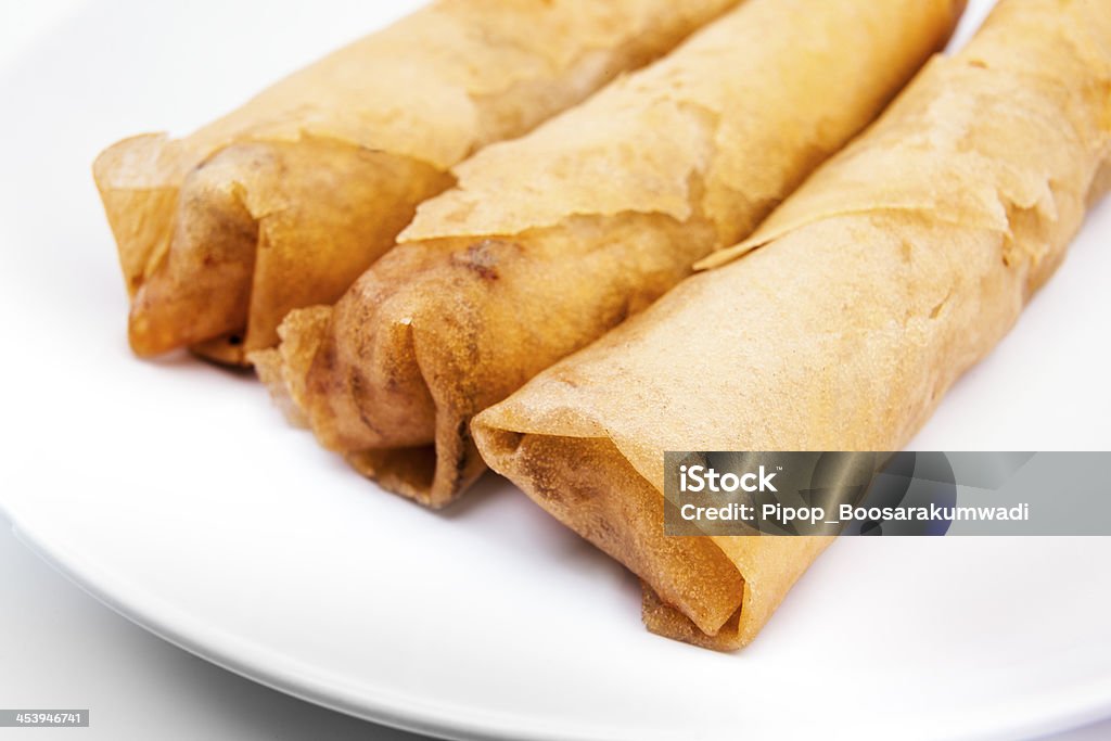 "Spring rolls" (Dim sum or Loempia), cuisine on white background. Spring rolls are a large variety of filled, rolled appetizers. The name is a literal translation of the Chinese food, found in East Asian and Southeast Asian cuisine. The kind of wrapper, fillings, and cooking technique used, as well as the name, vary considerably within this large area. Asian Culture Stock Photo