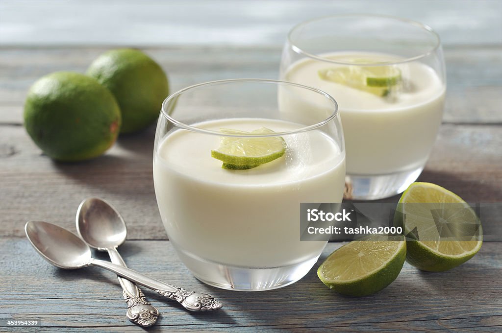 Panna cotta with fresh lime Italian dessert panna cotta with fresh lime in glass on wooden background Panna Cotta Stock Photo