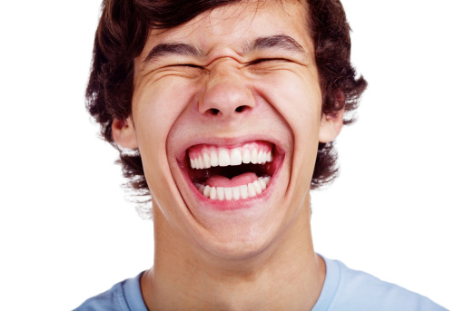 Close up portrait of loudly laughing young man isolated on white background