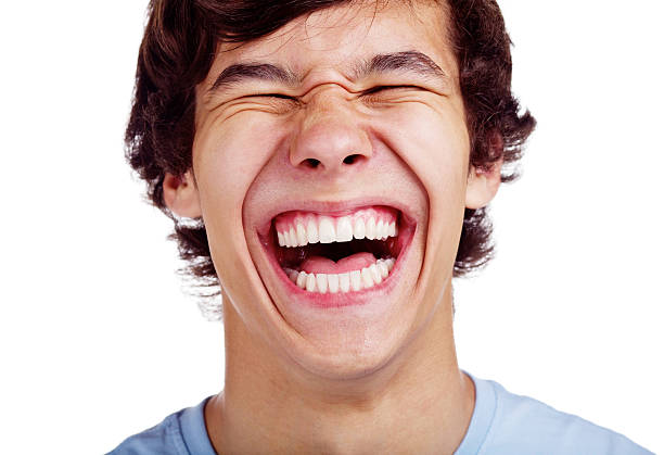 Happy teenage laugh closeup Close up portrait of loudly laughing young man isolated on white background teeth photos stock pictures, royalty-free photos & images