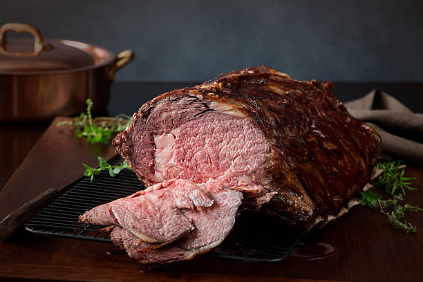 Sliced Prime Rib Roast - XXXL A prime rib roast beef, sliced open to show medium rare meat. Very shallow DOF. Beef stock pictures, royalty-free photos & images