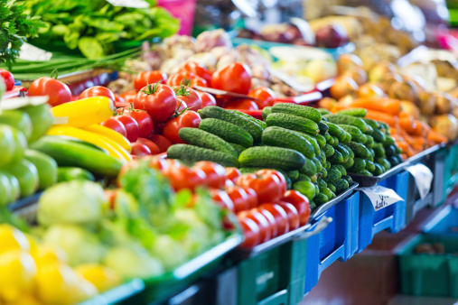 business Woman with shopping cart, picking vegetables at grocery store