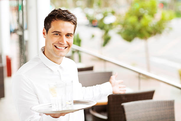 istock Waiter Holding Tray While Welcoming In Restaurant 453969361