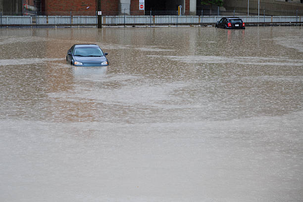 Inundado estacionamento com dois submerso carros - foto de acervo