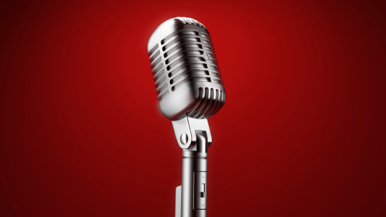 Old Chrome microphone isolated on red background