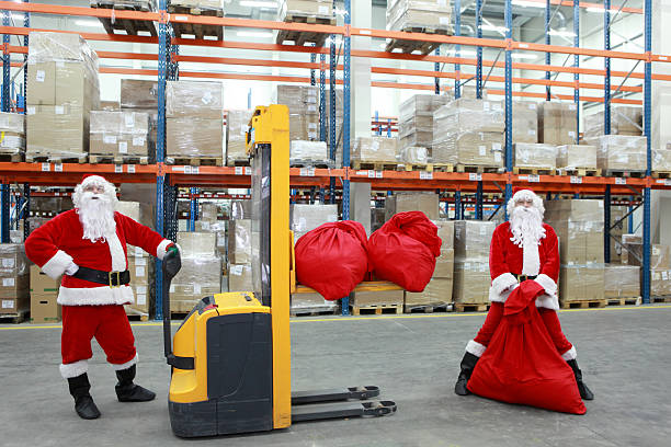 istock two santa clauses workers at work in large storehouse 453981927