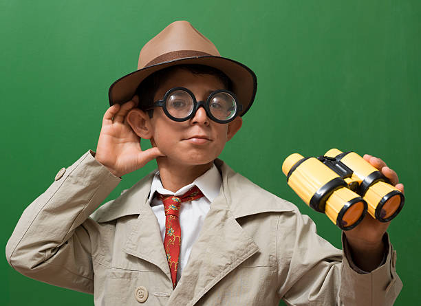 istock Little detective holding binoculars in front of blackboard 453983109