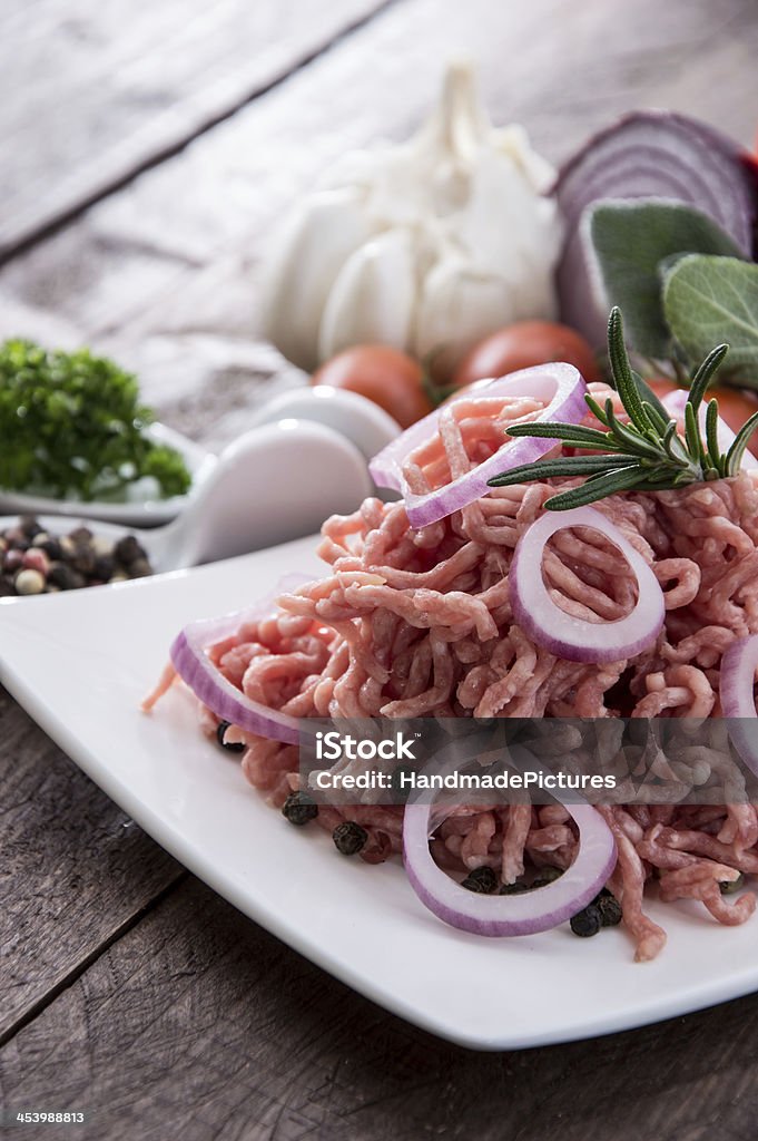 Plate with portion of Minced Meat Plate with portion of Minced Meat on wooden background Barbecue - Meal Stock Photo