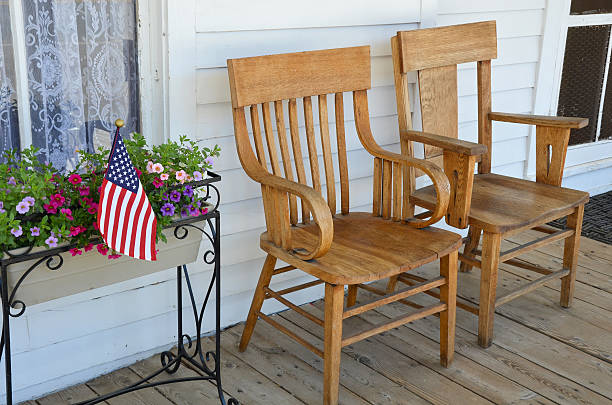 Deck chair on a stone patio overlooking a vast forest and mountain landscape on a sunny day.