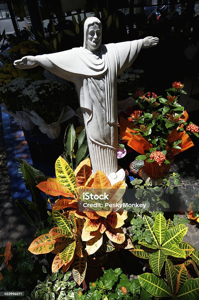 Statue of Jesus Christ with Arms Spread Brazilian Flower Stall Statue of Jesus Christ standing with arms spread over plants at a Brazilian flower stall in Rio de Janeiro Christ The Redeemer Stock Photo